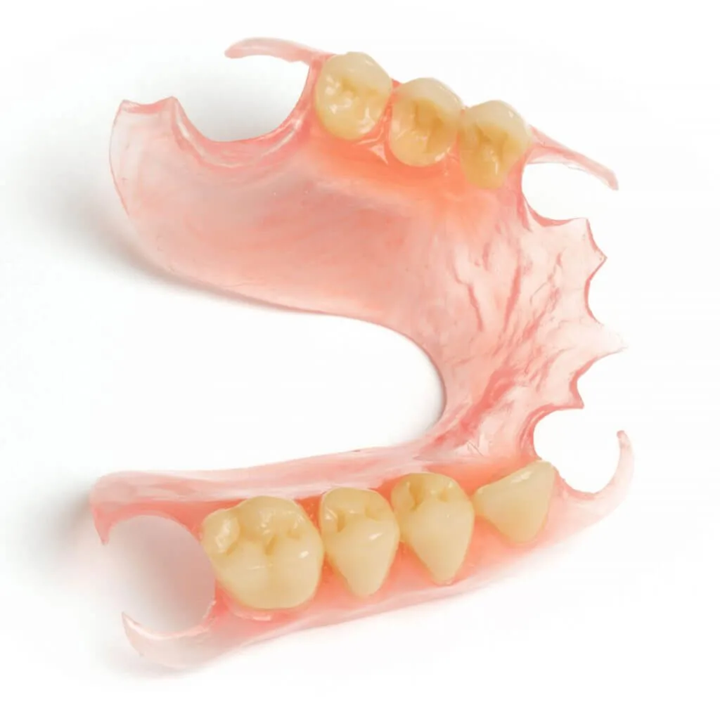 Prótesis dental parcial flexible con base rosada y dientes artificiales